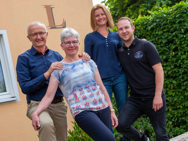 Ein Teil des Teams steht vor dem Eingang des Hotels