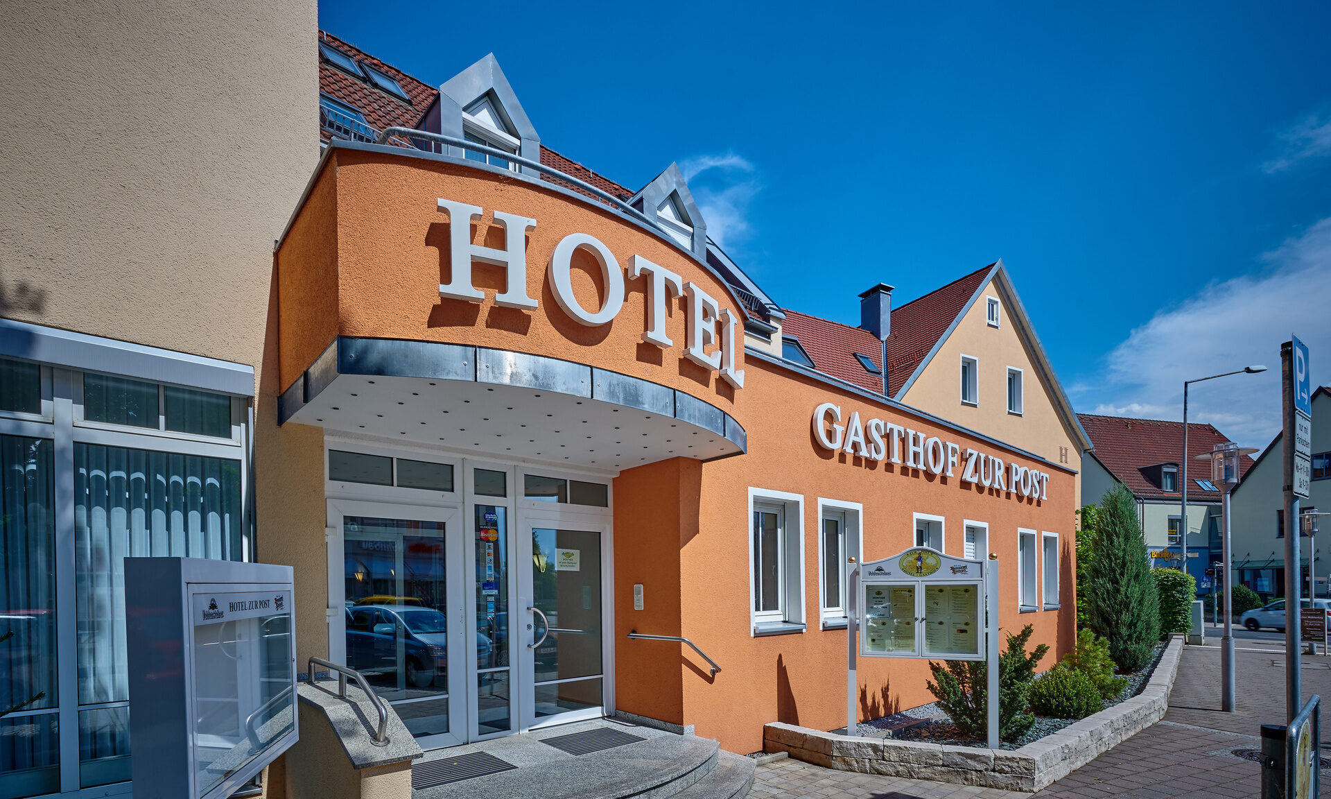 Das orange Geb&auml;ude des Hotels im N&uuml;rnberger Land an einem sonnigen Tag