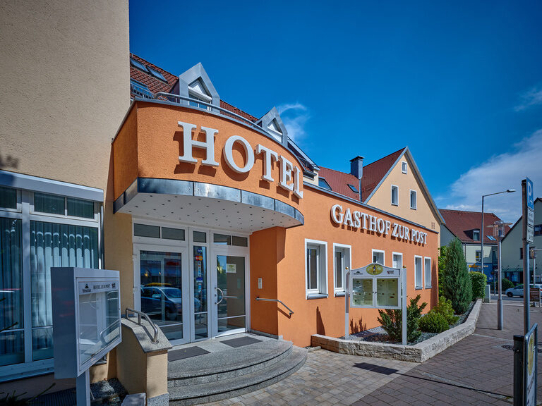 Das orange Gebäude des Hotels im Nürnberger Land an einem sonnigen Tag