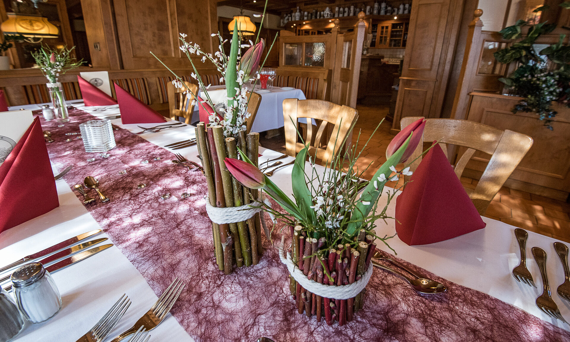 Auf einem Tisch im Hotel zur Post in Lauf im N&uuml;rnberger Land sind mit Holz dekorierte Tische gedeckt.