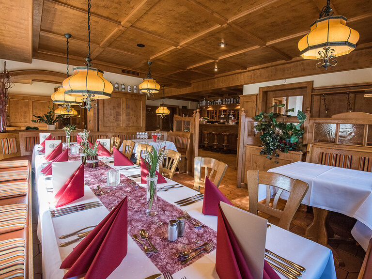 Die Gaststube ist für das Mittagessen gedeckt und mit Blumen geschmückt