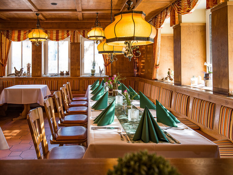 Eine Aufnahme von gedeckten Tischen an einer Eckbank mit Stühlen.